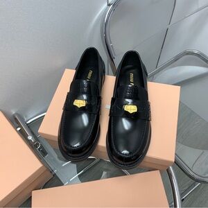 Miu Miu Shiny Black Loafers with Gold Accent